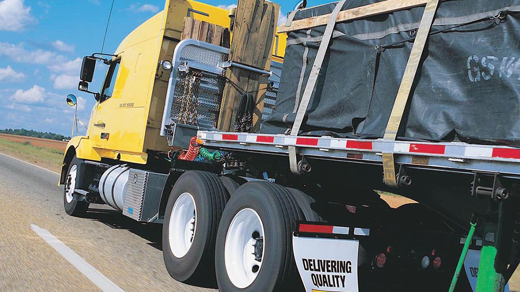 yellow 18-wheeler with cargo